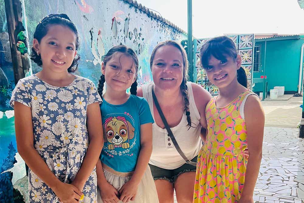 Woman posing with Nicaraguan children on an immersion trip.